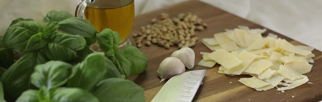 pesto ingredients on a wooden cutting board.