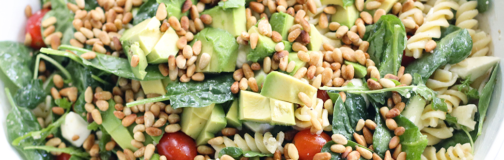 Close-up view of a lettuce and pasta salad with Greek dressing