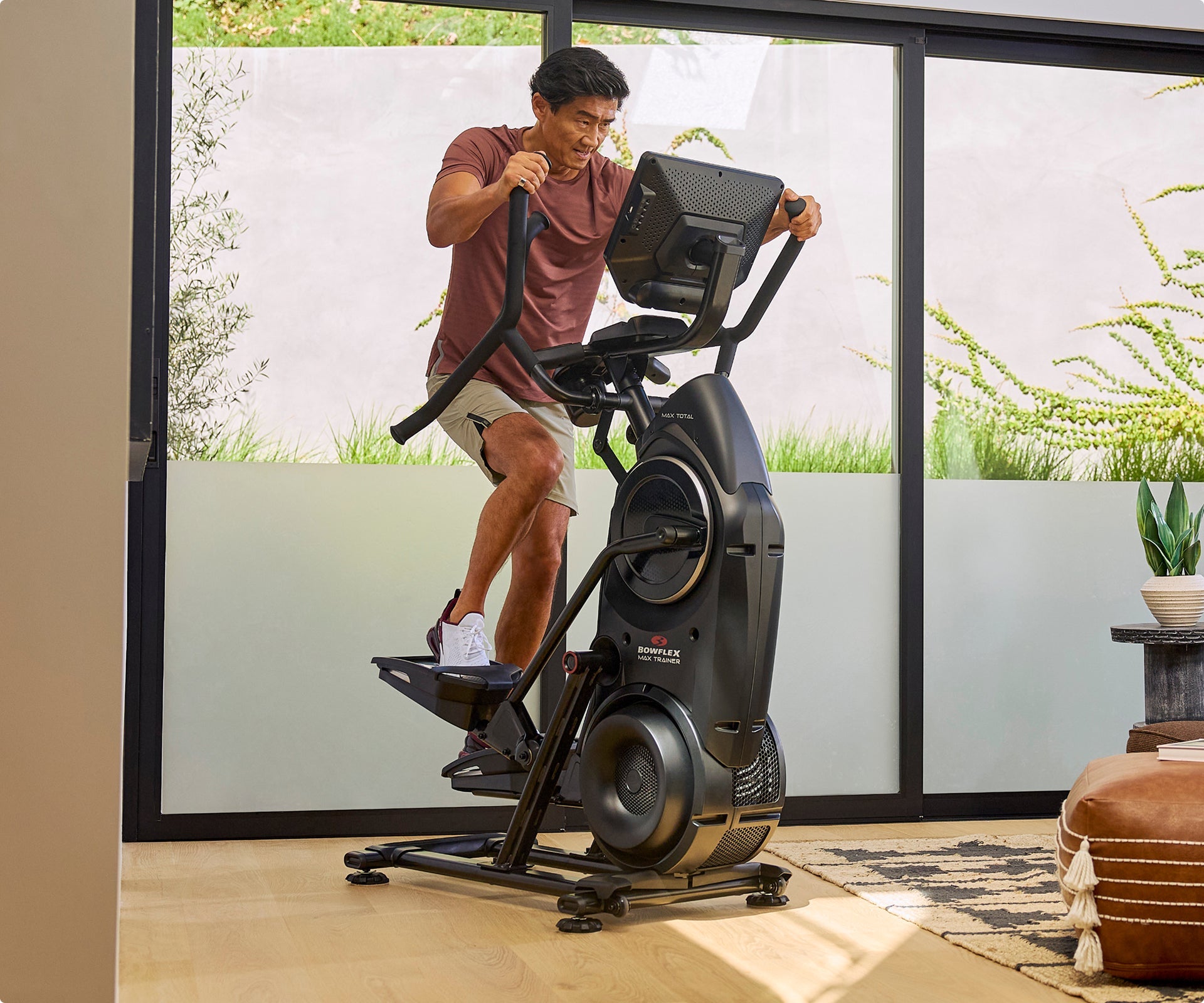 Man exercising on a BowFlex Max Total 16 in a home setting.