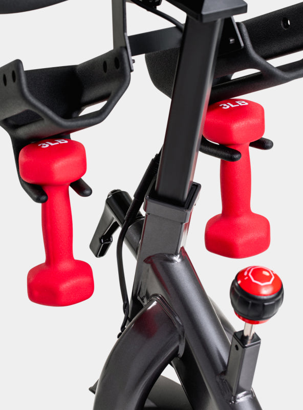 A pair of 3 pound dumbbells in cradles on the BowFlex C6 Bike.