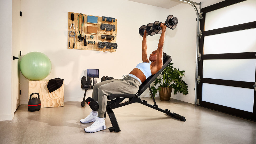 Woman exercising with a pair of Results Series 552 dumbbell