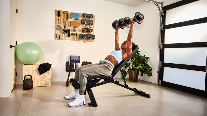 Woman exercising with a pair of Results Series 552 dumbbell