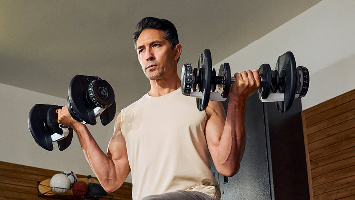 Man doing a curl with the BowFlex Results Series 90 SelectTech Dumbbells 