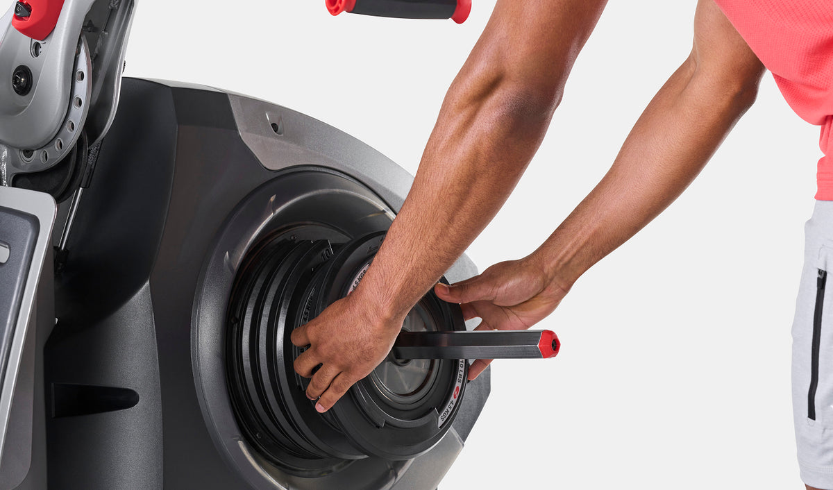 Hands adjusting the SpiraFlex® Technology resistance level on the BowFlex Revolution Home Gym.