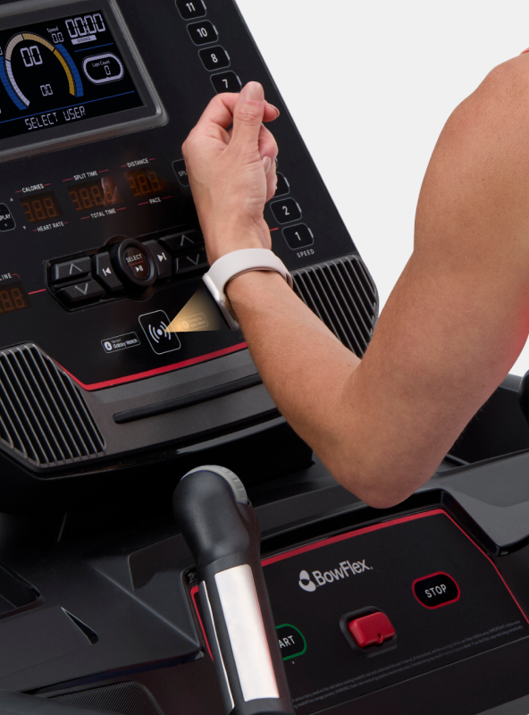 Person holding smartwatch up to the BowFlex T9 Treadmill console.