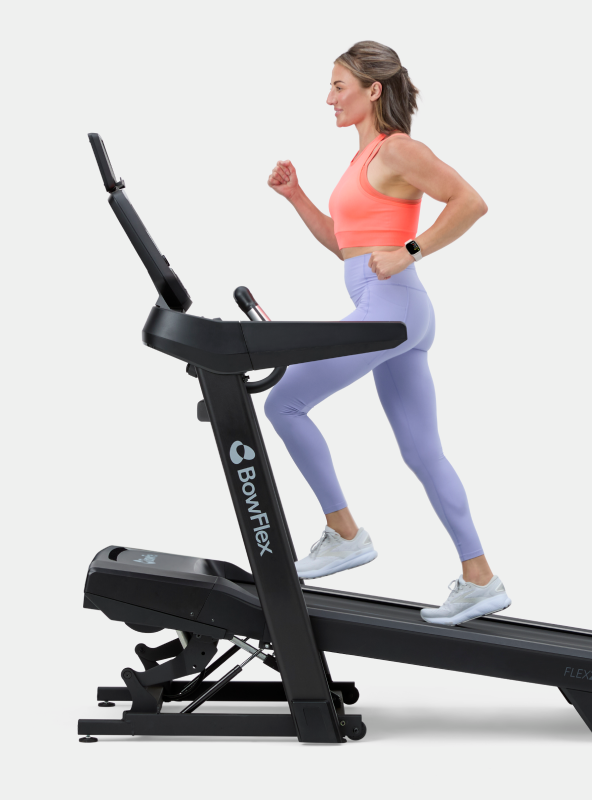 Woman running on an inclined BowFlex T9 Treadmill.