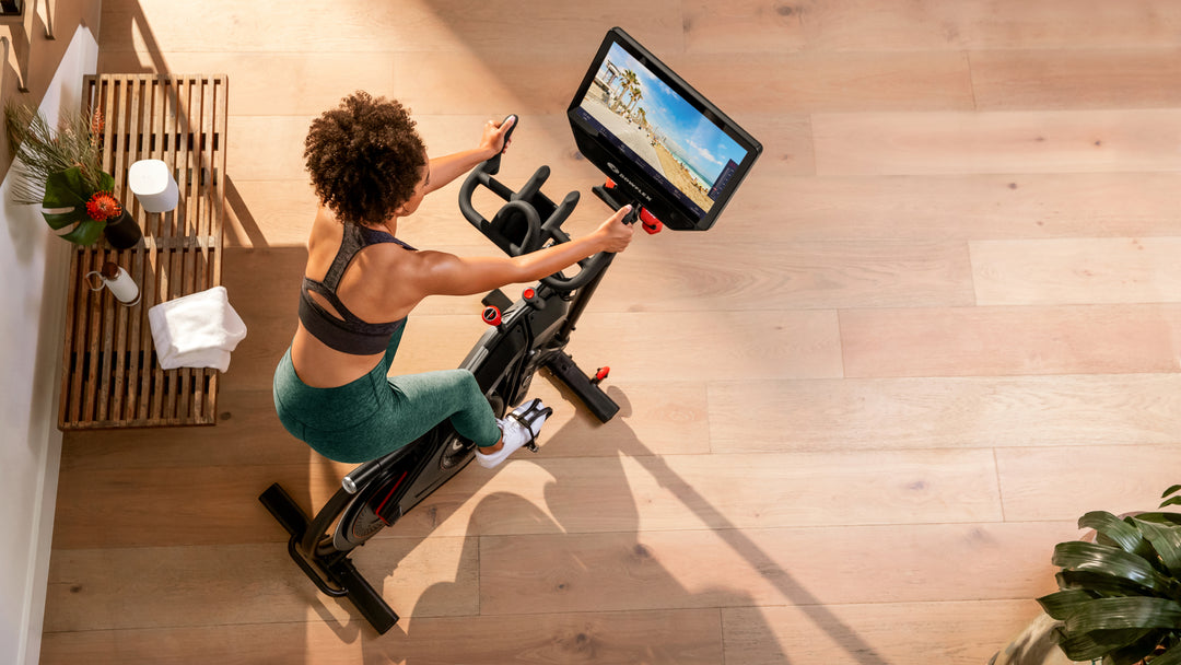 Person using a stationary bike with a screen in a home setting