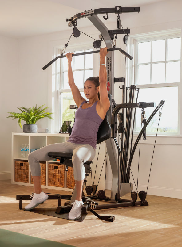 Woman using the BowFlex Xtreme 2 SE angled lat bar.