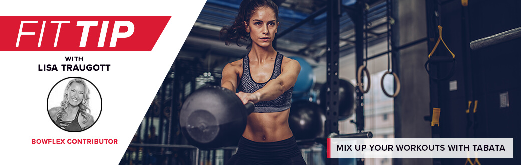 A fit woman in a gym swinging a kettlebell.