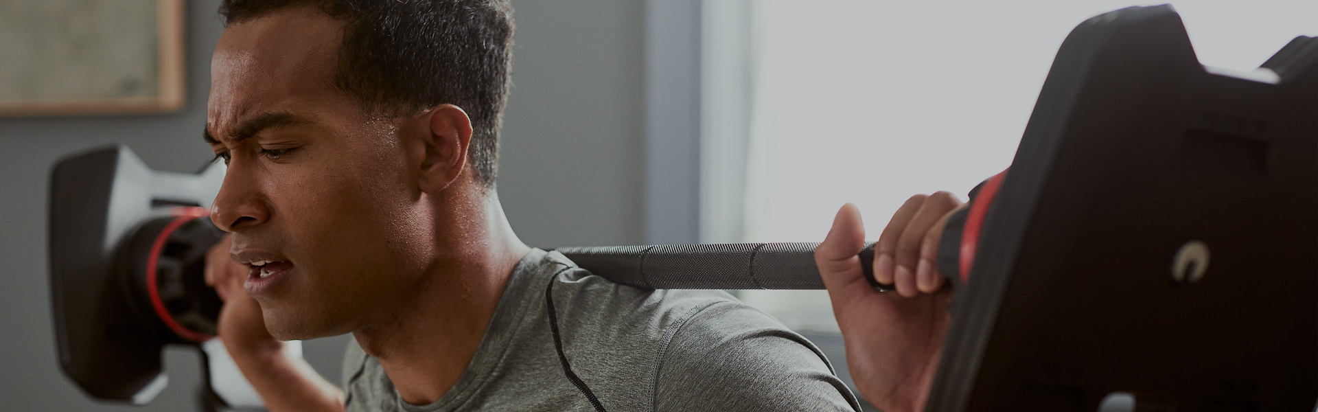 Muscular man working out with the SelectTech Adjustable Barbell