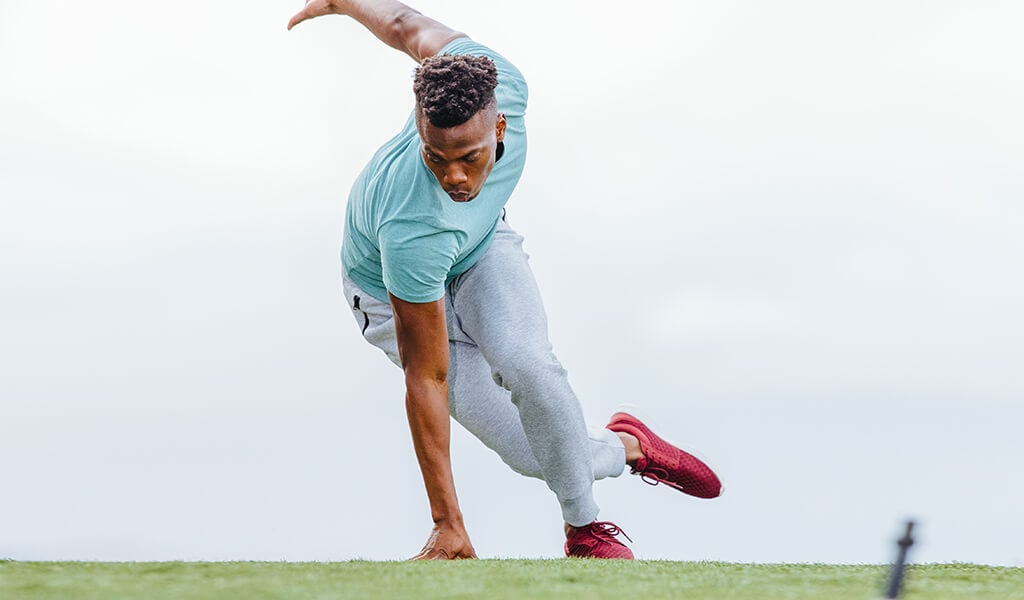 A fit man performing skaters outside.