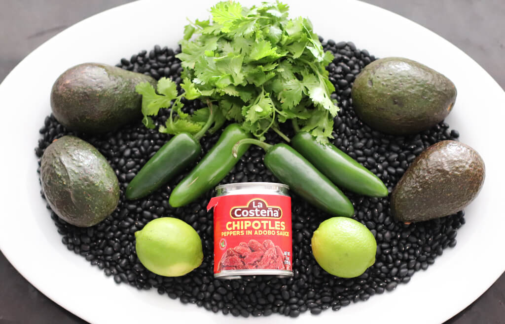 avocados, cilantro, black beans, and peppers on a plate.