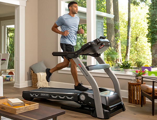 man running on a BXT216 Treadmill in a sunny room