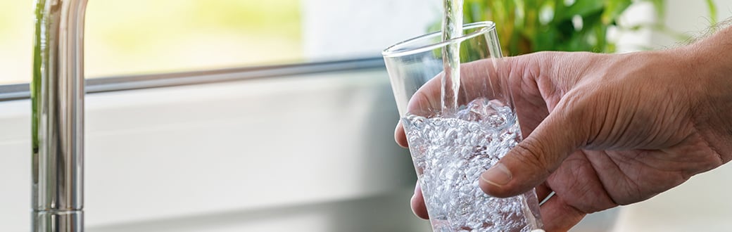 Glass of water being filled from the tap