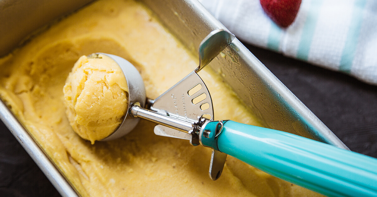Scooping mango ice cream.