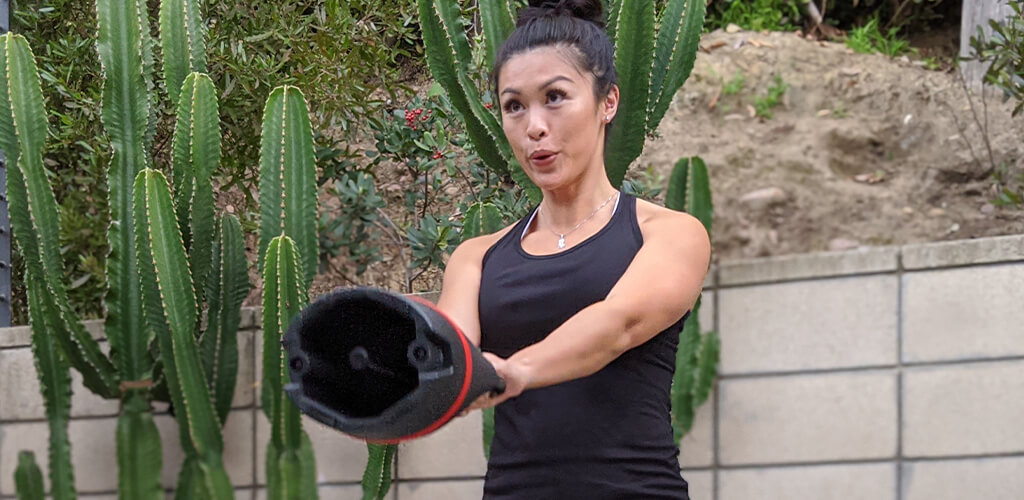 A woman using a BowFlex 840 Kettlebell.