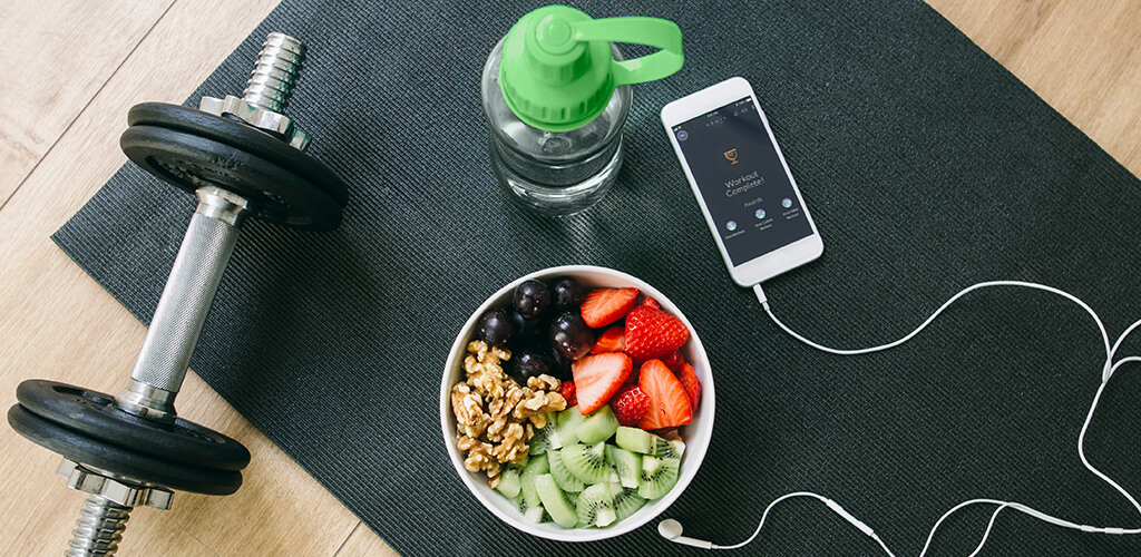 healthy snacks sitting on a workout mat next to a dumbbell
