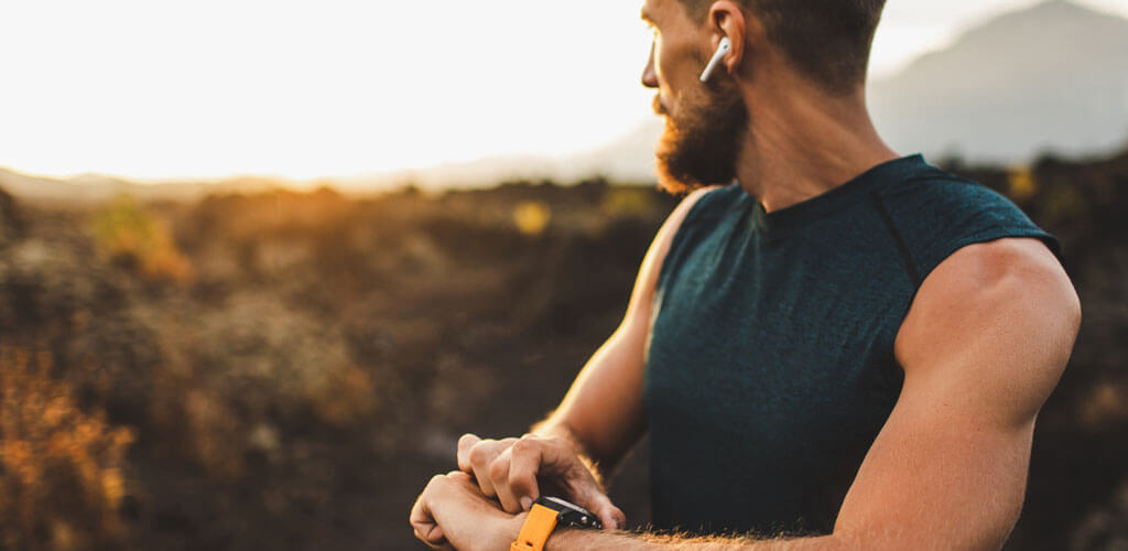 A man outdoors working out listening to music.