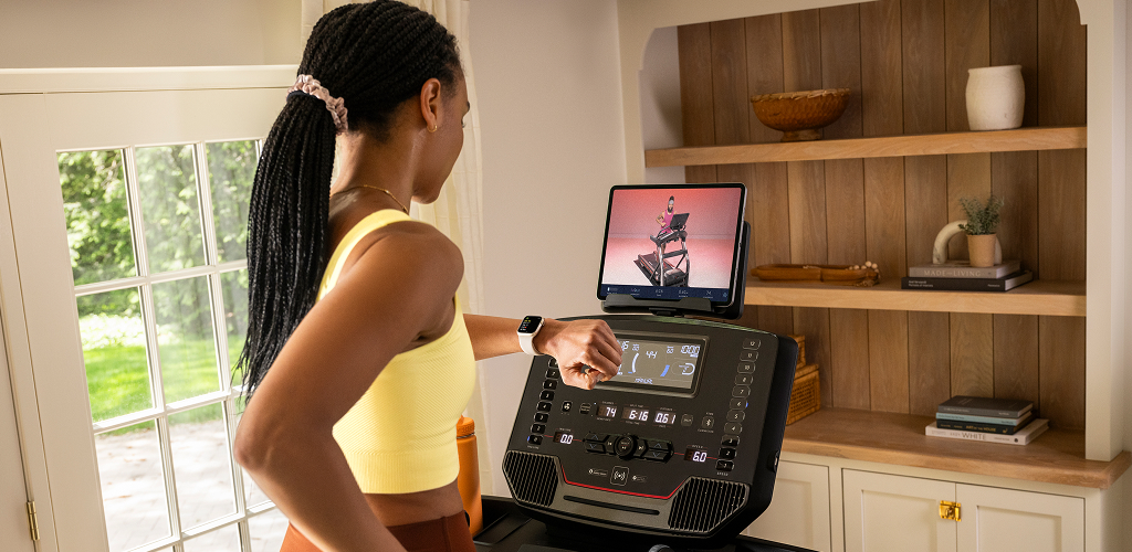 woman on a bowflex treadmill looking at her watch