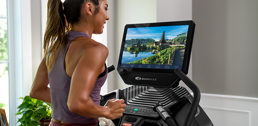 A woman using BowFlex JRNY on a BowFlex Treadmill.