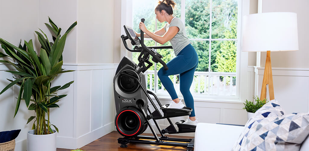 A woman using a BowFlex Max Trainer for HIIT.