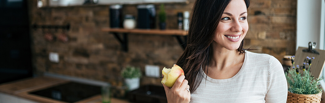 A woman holding an apple.