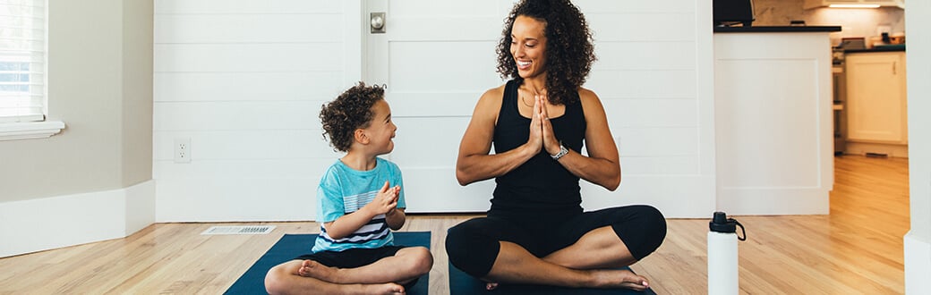 A woman and a child doing yoga.