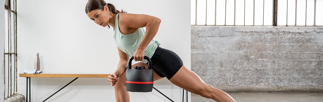 A woman performing a single arm kettlebell row.