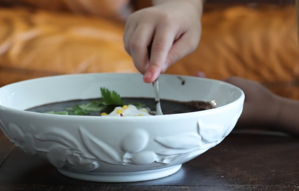 A child eating black bean soup.