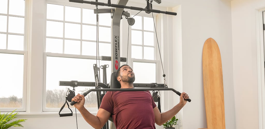 man using bowflex home gym