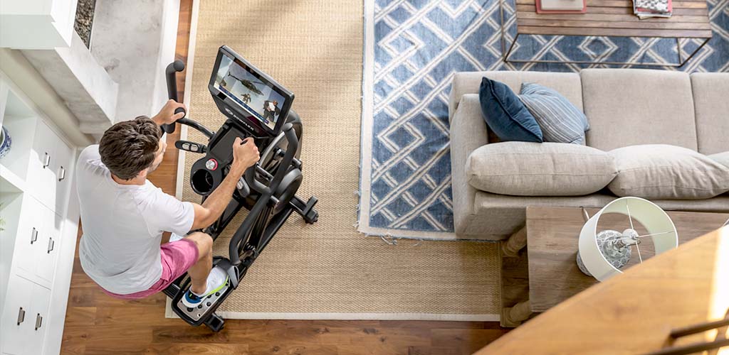 A man working out on a Max Total 16 compact elliptical.