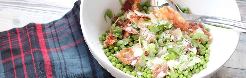 A bowl of pea, prosciutto, and parmesan salad.
