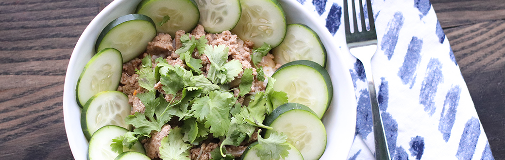 Thai ground turkey salad with sliced cucumbers in a bowl