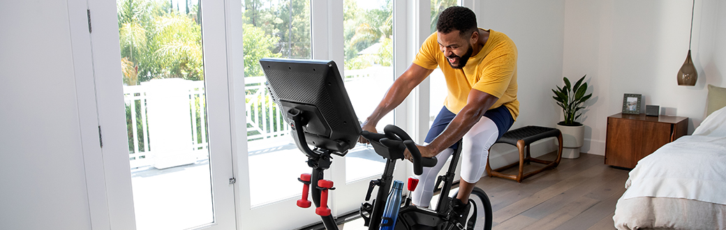 A man working out on a BowFlex VeloCore exercise bike.