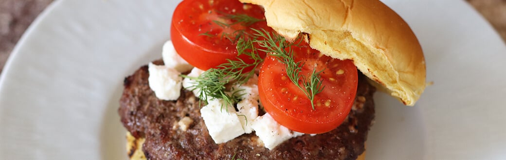 A burger patty cooking on a grill