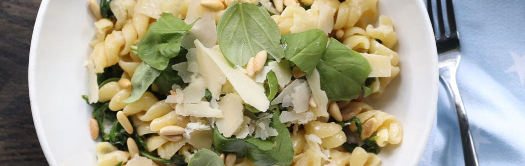 Lemon and arugula pasta salad on a plate.