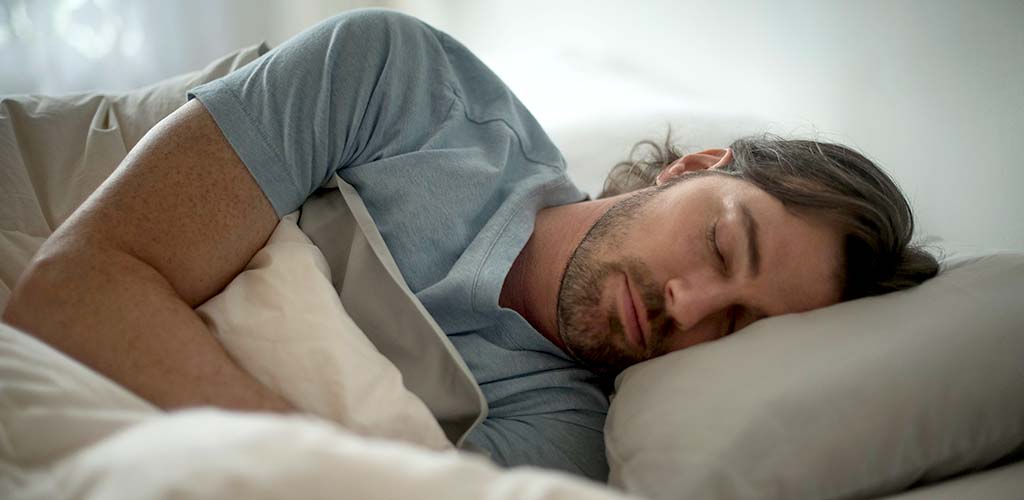 A man sleeping in a bed.