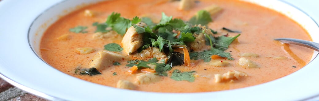 chicken coconut curry soup in a white bowl