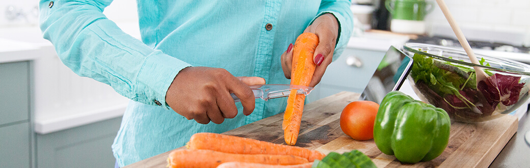 A person peeling a carrot