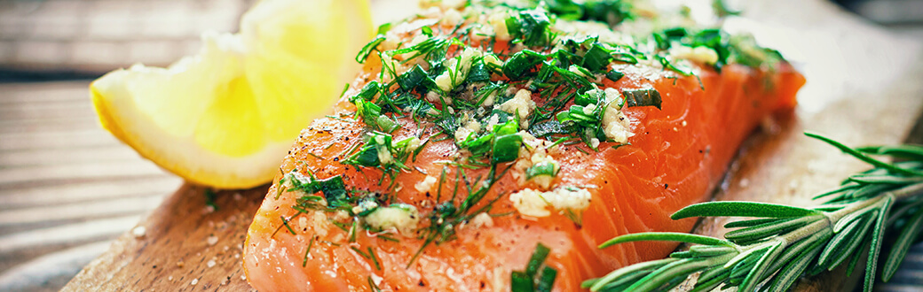 A salmon fillet topped with herbs.