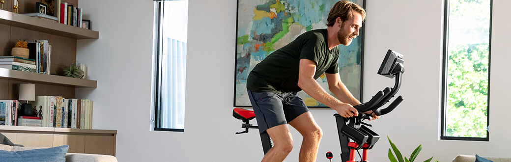 A man riding a BowFlex indoor cycling bike.
