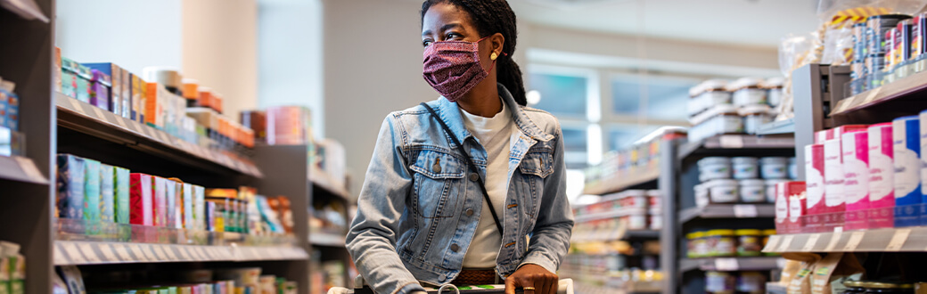 A person with a mask on grocery shopping.