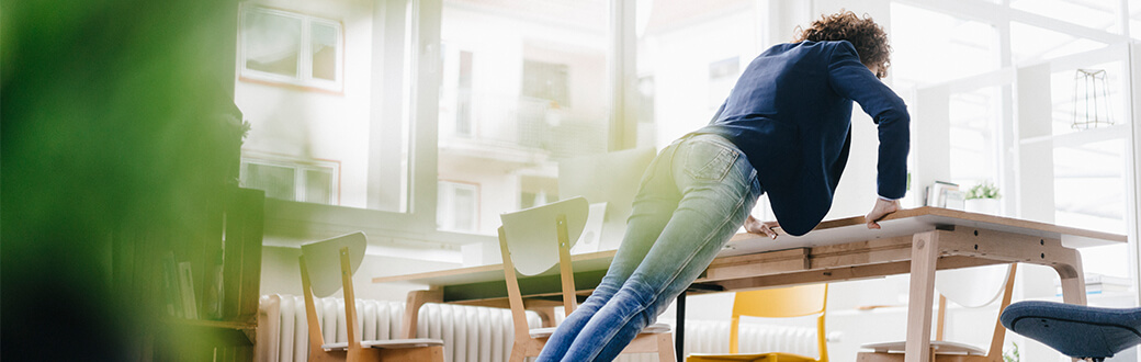 A woman performing a desk push up.