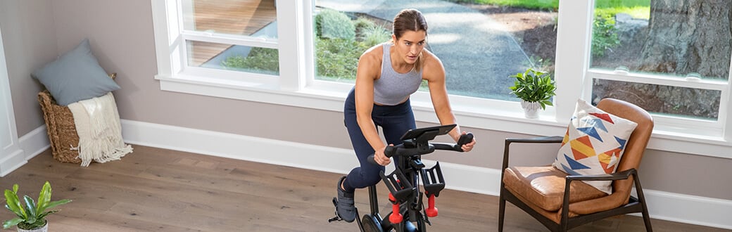 A woman using a BowFlex Indoor Cycling Bike.