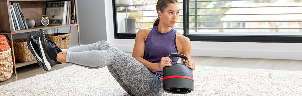 A woman working out with a Bowflex 840 Kettlebell.