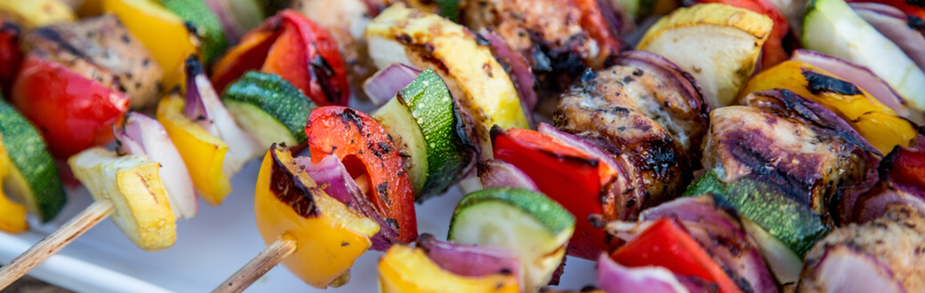Grilled chicken and veggie kabobs on a plate.