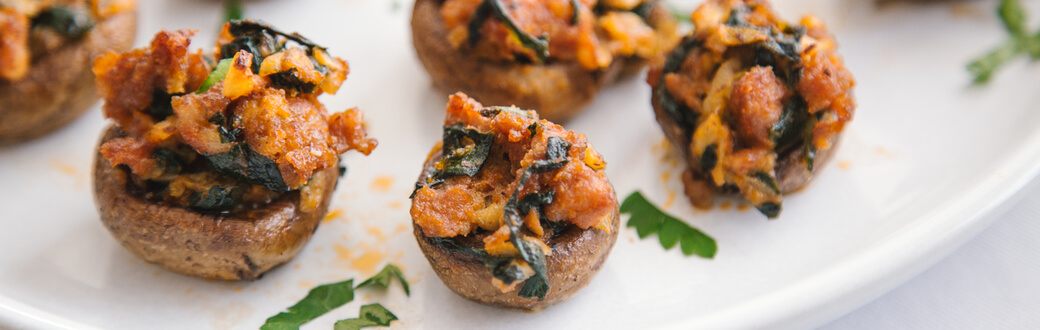 A plate of chorizo and spinach stuffed mushrooms.