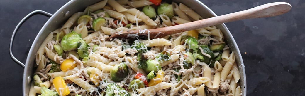 Pasta primavera topped with cheese.