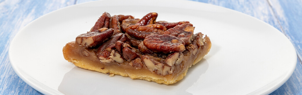 Piece of pecan pie bar on a plate.