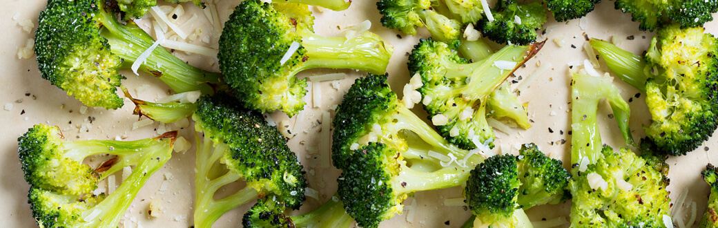 Roasted broccoli florets topped with Parmesan cheese.